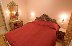 坦佩雷芒果酒店的一间卧室配有一张带红色床罩和镜子的床