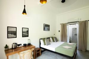 a bedroom with a bed and a wooden desk at The Well in Ahangama