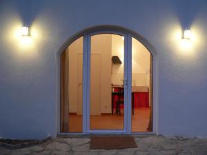 an arched window on a white wall with a kitchen at Casa do Hibisco in São João do Estoril