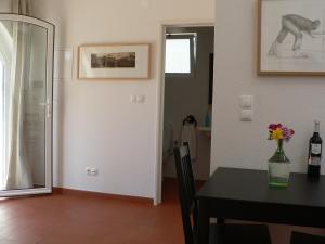 a dining room with a table and a vase of flowers at Casa do Hibisco in São João do Estoril +24 photos