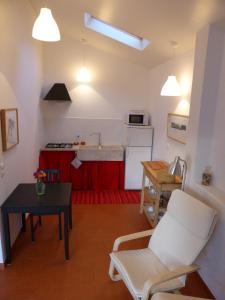 a living room with a table and a kitchen at Casa do Hibisco in São João do Estoril