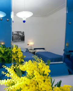 um quarto com uma cama, um espelho e flores amarelas em White Vatican em Roma