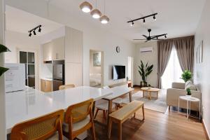 a white kitchen and living room with a table and chairs at Broga View Homestay in Semenyih
