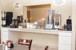 a counter in a coffee shop with a table and a chair at Super 8 by Wyndham Corydon in Corydon