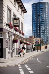 ロンドンにあるザ レイルウェイ タバーン ホテルの二人の人が通りを歩いている