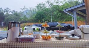 a table with food on it with cars in a parking lot at CBHResort Agrofarm in Kampong Benchah Tualang