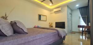 a bedroom with a large bed and a television at CBHResort Agrofarm in Kampong Benchah Tualang