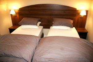 dos camas sentadas una al lado de la otra en una habitación en The Railway Tavern Hotel, en Londres