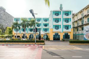 a large blue building with palm trees in front of it at Wave Hotel Pattaya in Pattaya