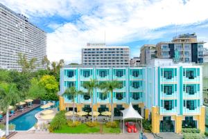 a blue building with a pool in a city at Wave Hotel Pattaya in Pattaya