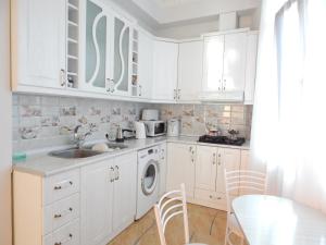 Una cocina blanca con fregadero y lavavajillas. en Guesthouse Agmashenebeli Sea side, en Kobuleti