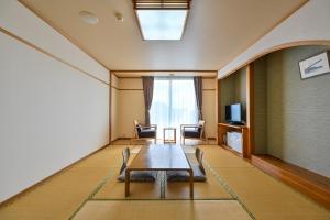 a room with a table and chairs and a television at Kaikyo View SHIMONOSEKI - Vacation STAY 13686v in Shimonoseki