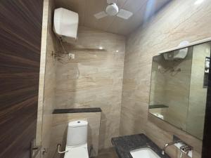 a bathroom with a toilet and a sink and a mirror at Khatu Bagh Resort in Sīkar