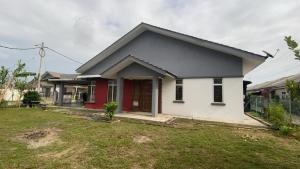 a white and red house with a yard at HasYaa Homestay in Kampong Bukit Kuang