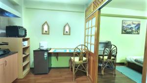 a room with a desk and chairs and a bed at Tiny Haven Apartment at Greentara Heritage Home in Pātan