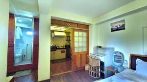 a room with a bed and a bathroom with a kitchen at Tiny Haven Apartment at Greentara Heritage Home in Pātan +12 photos