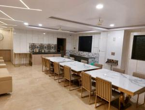 a large room with tables and chairs and a kitchen at Reside Inn in Bangalore