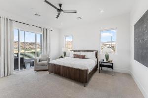 Un dormitorio con una cama y una silla y ventanas. en Villa #46 at Bloomington Country Club condo, en St. George