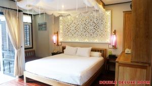 Postel nebo postele na pokoji v ubytování Hoi An Pho Library Hotel