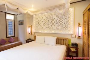 Postel nebo postele na pokoji v ubytování Hoi An Pho Library Hotel