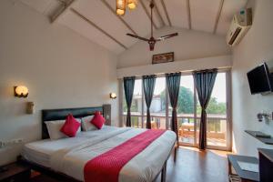 Un dormitorio con una cama grande y una ventana grande. en Swizel Nook Stay, en Goa