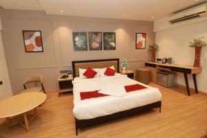 a bedroom with a bed and a table and a desk at Sri Vishnu Inn in Bengaluru