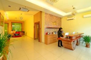 a woman standing at a desk in a lobby at Rimba Hotel in Kuala Terengganu