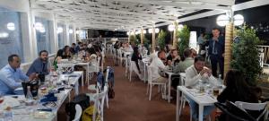 a group of people sitting at tables in a restaurant at Residence La Bricola Sestante 26 in I Casoni