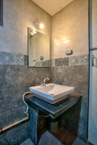 un baño con lavabo y espejo en Swizel Nook Stay, en Goa 62 fotos más