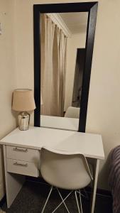 a white desk with a mirror and a chair at Self catering unit near Airport Beach St George's Park in Gqeberha