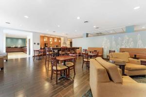 a restaurant with tables and chairs and a bar at Sleep Inn & Suites Cumberland in Cumberland