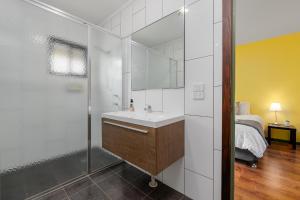 a bathroom with a sink and a shower and a bed at Elysian Bridgetown in Bridgetown +51 photos
