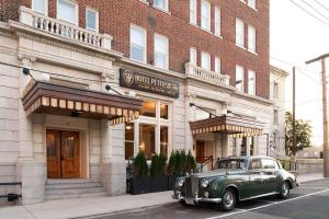 an old green car parked in front of a building at Hotel Petersburg, Tapestry Collection By Hilton in Petersburg