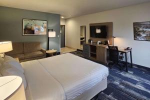a hotel room with a large bed and a desk at Edgewater Inn and Suites, an Ascend Collection Hotel in Coos Bay