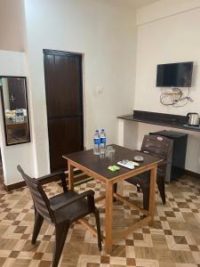 a table with two chairs and two bottles of water on it at Calangute Beach Prime in Calangute