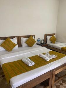 two beds sitting next to each other in a room at Calangute Beach Prime in Calangute