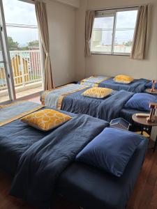 a room with four beds with pillows on them at The Villa Lino in Yomitan