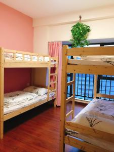a room with three bunk beds and a window at YoYo Youth Apartment in Guangzhou