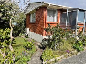 a brick house with a garden in front of it at Rosy at Roslyn in Dunedin