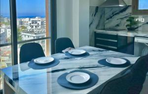 a table with chairs and plates on top of it at Magic Vista Exclusive Luxury Duplex by HolidayKeys in Kérynia +21 photos