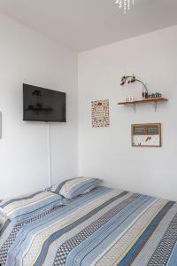 a bedroom with a bed with a tv on the wall at Praia de Icarai a 500m in Niterói