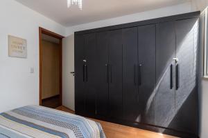 a large black cabinet in a bedroom with a bed at Praia de Icarai a 500m in Niterói