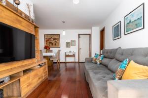 a living room with a couch and a flat screen tv at Praia de Icarai a 500m in Niterói +12 photos