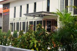 a white building with plants in front of it at Juntima Place at Amphawa in Amphawa