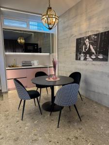 a dining room with a table and chairs and a kitchen at Stari Toranj VI studio apartman in Vukovar +9 photos