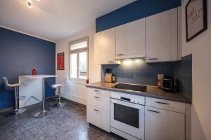a kitchen with white cabinets and a sink at Boutique Apartment Lakeview Luzern 1 in Luzern