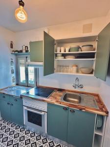 a kitchen with blue cabinets and a sink at Accommodation near the Cathedral LaCuevitadeLeo in Toledo