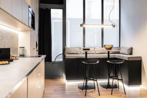 eine Küche mit einer Bar mit Hockern in der Unterkunft Luxury Suite 2BR in Charming Courtyard Le Marais in Paris + 11 Fotos