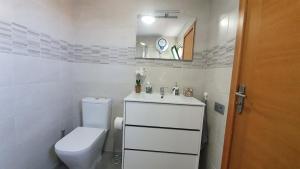 Un baño con inodoro, lavabo y espejo. en Hera House, en Parque Holandes 12 fotos más