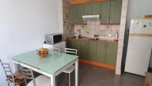 una cocina con una mesa y un refrigerador en Hera House, en Parque Holandes